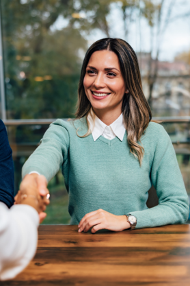 A person shaking hands in a job interview.
