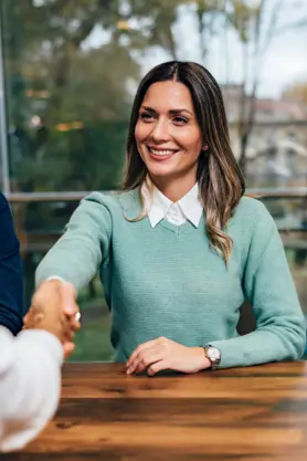 A person shaking hands in a job interview.