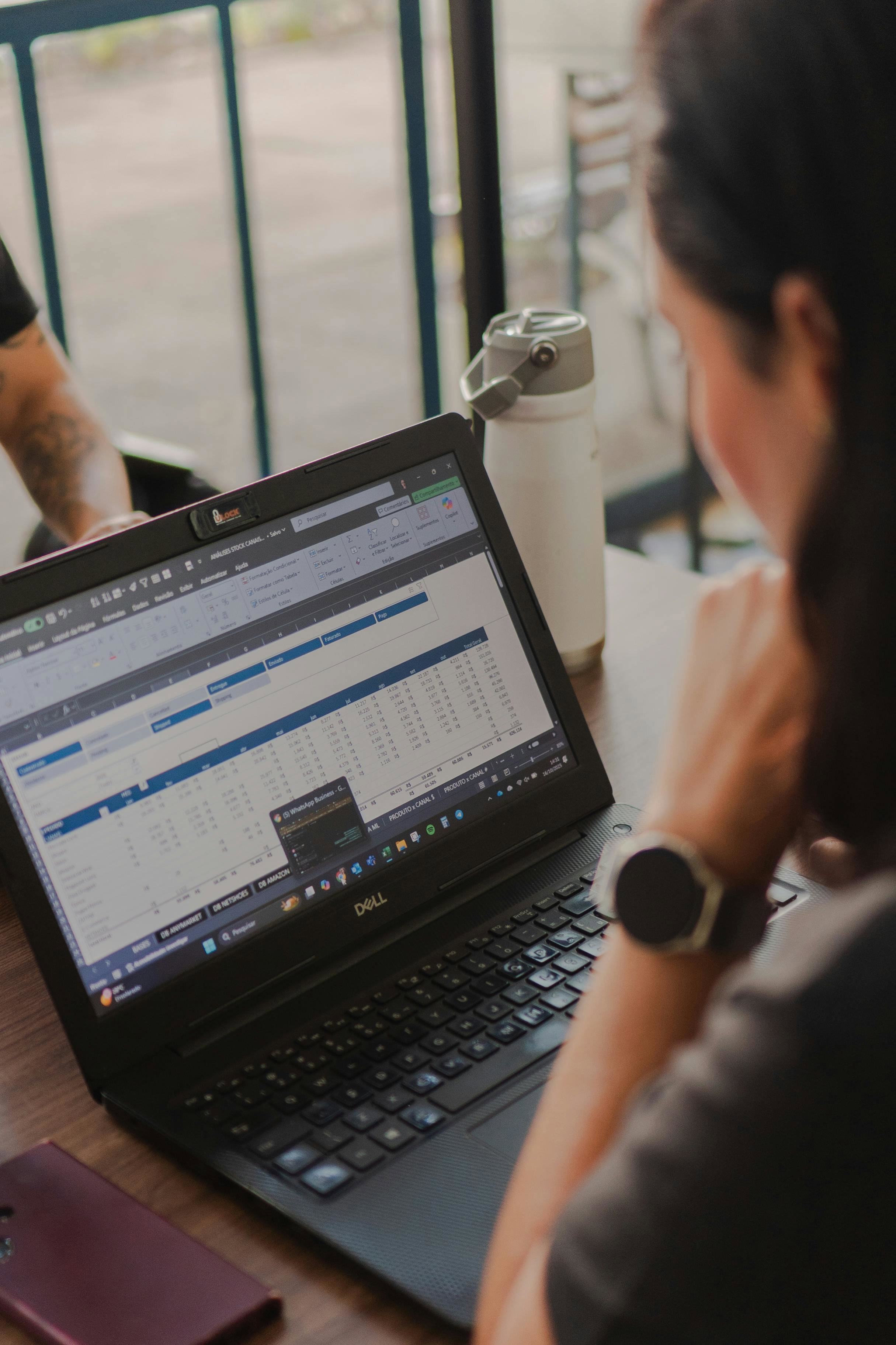 A Business Analyst working on a laptop at a desk.