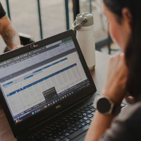 A Business Analyst working on a laptop at a desk.