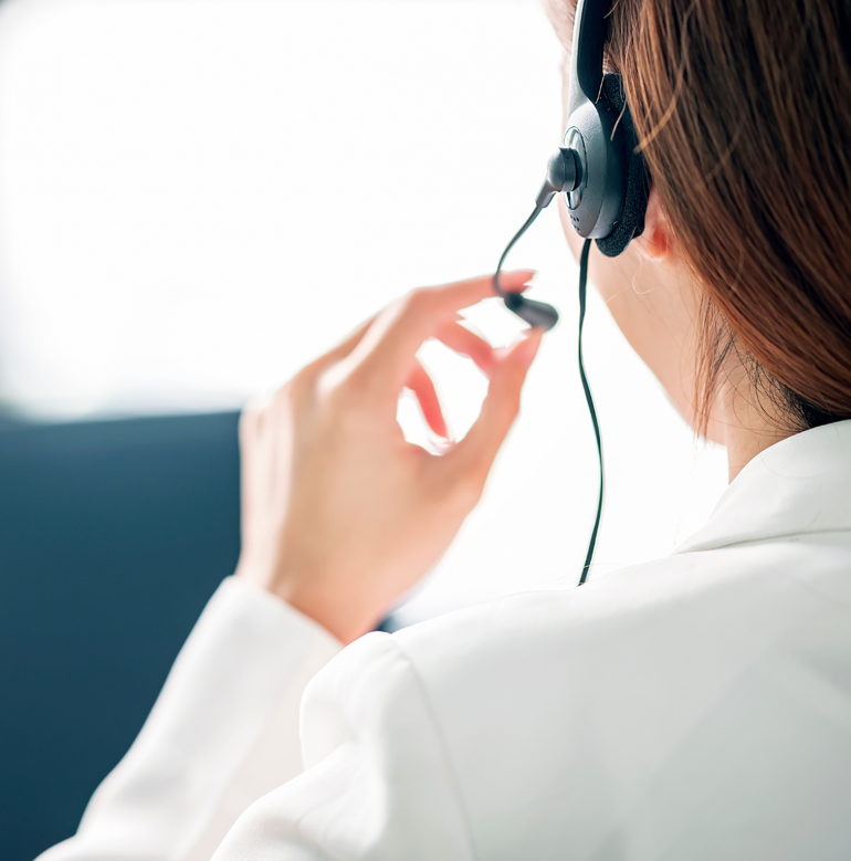 A professional using a headset at a computer.
