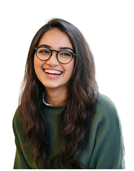 A young woman with long, wavy dark hair and glasses smiles brightly. She is wearing a green sweater and is set against a plain white background.