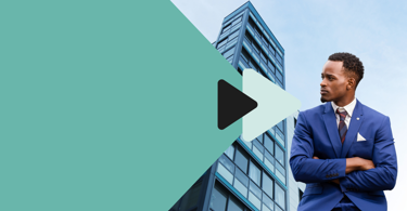 A man in a blue suit stands with arms crossed in front of a modern glass building, overlaid with teal shapes and a black play button graphic on the left side of the image.