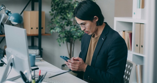 A man researches Business Analyst roles at his desk, reflecting the first steps of moving into business analysis.