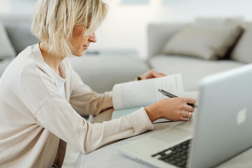 A person studying at home with a laptop and notebook.