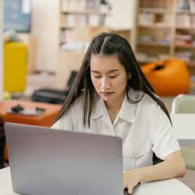 A Business Analyst working on a laptop at a desk.
