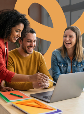 A team of people working and smiling together in an office at a laptop.