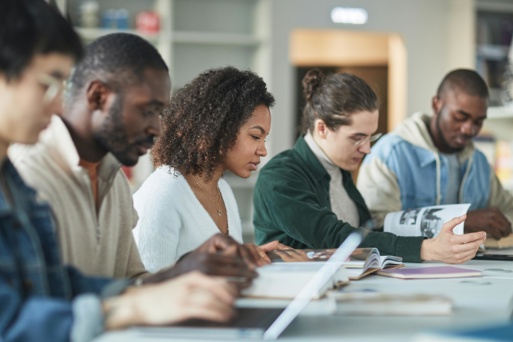 University students studying together at a table with books and notes.