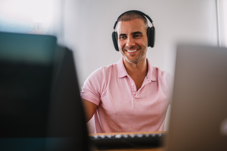 40 year old working at a computer with headphones on.
