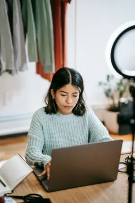 A person sitting at a desk using a laptop, to search for IT jobs.