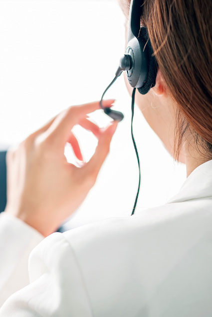 A professional using a headset at a computer. 