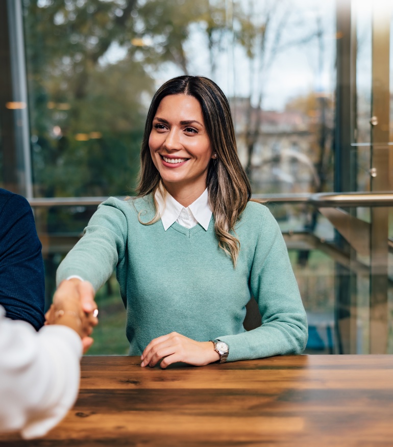 A person shaking hands in a job interview.