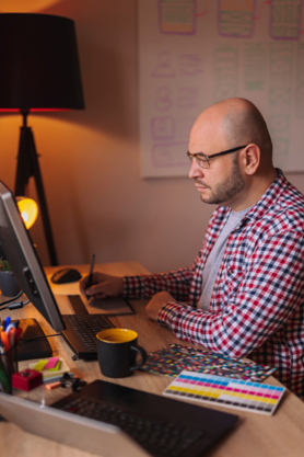 A Web Designer working on a computer at a desk.