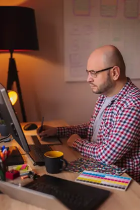A Web Designer working on a computer at a desk.