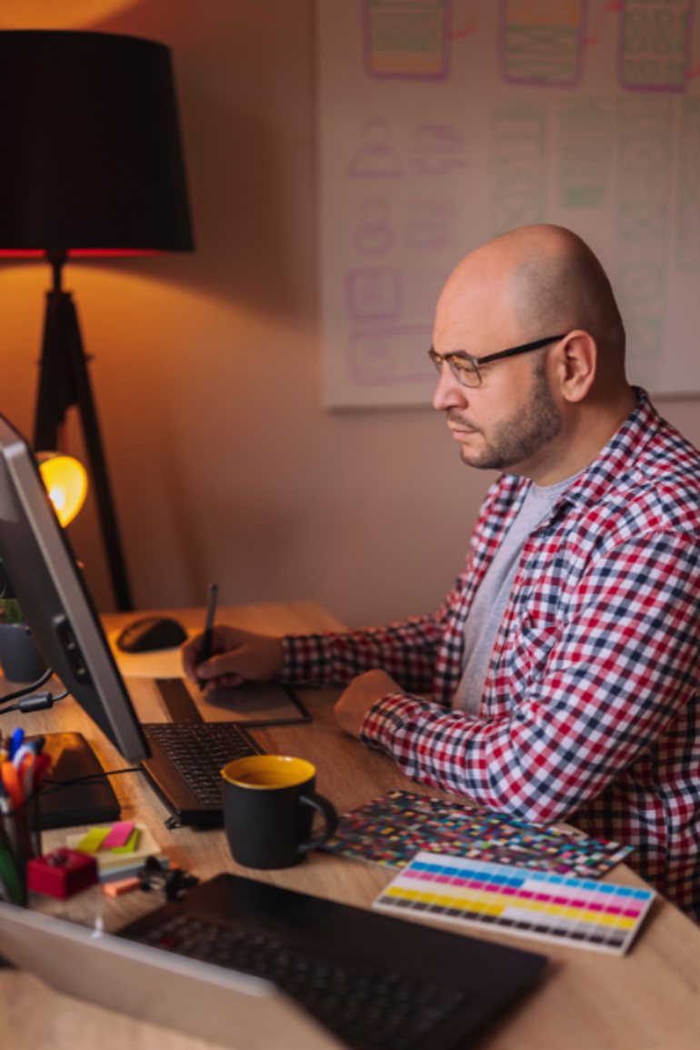 A Web Designer working on a computer at a desk.