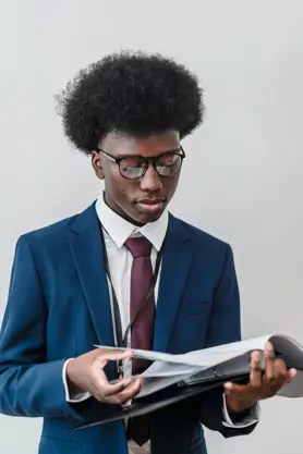 A Business Analyst looking through a physical file of documents.