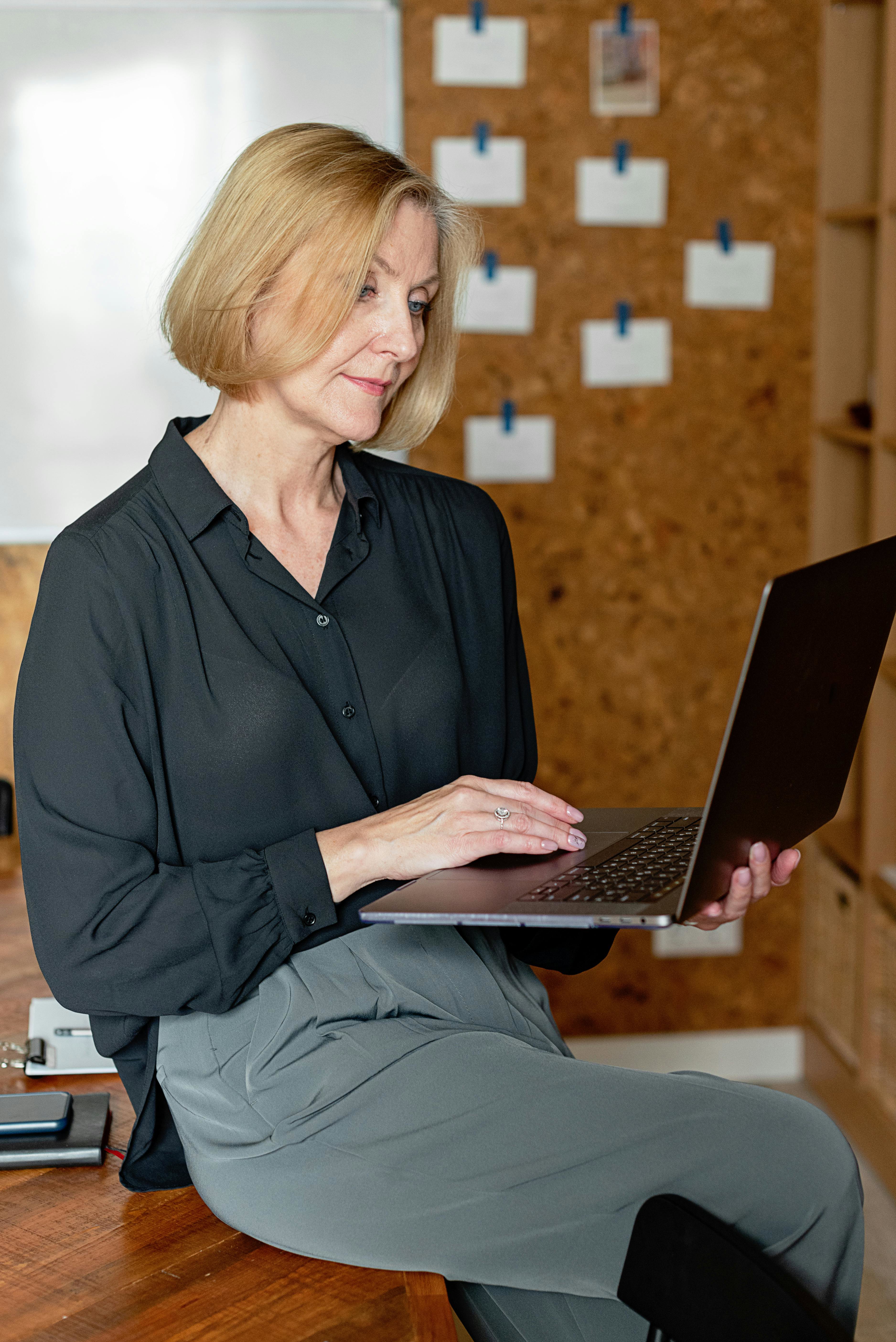 A middle-aged person on a laptop researching new jobs. 