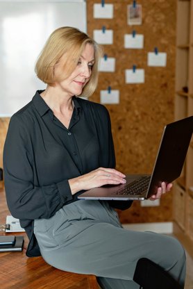 A middle-aged person on a laptop researching new jobs.