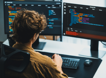 Tech professional working at a desktop computer.