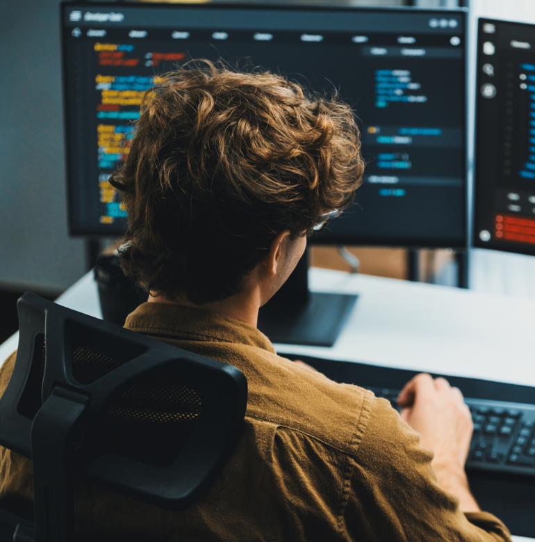 Tech professional working at a desktop computer.