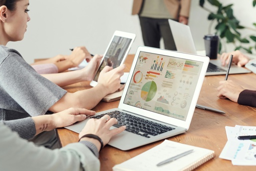 Team reviewing business analytics dashboards on a laptop during a workplace meeting.